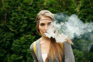 Happy vaping young white blonde girl photo