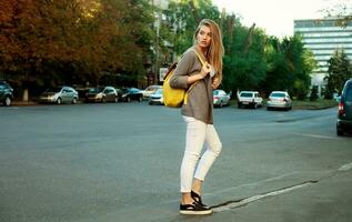 Fashion pretty young woman wearing yellow backpack photo