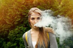 Happy vaping young white blonde girl photo