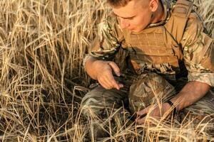 Soldier man standing against a field photo