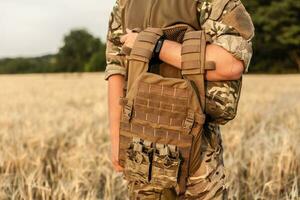 Soldier man standing against a field photo