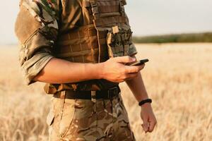 Mid section of military soldier using mobile phone photo