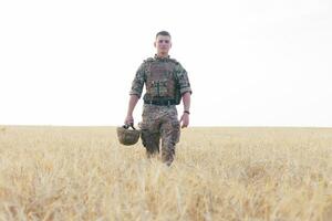 Soldier man standing against a field photo