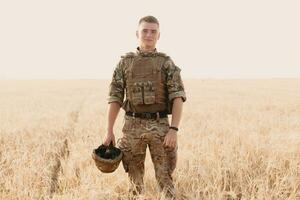 Soldier man standing against a field photo