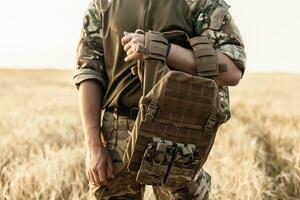 Soldier man standing against a field photo