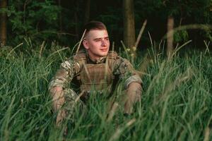 Soldier man standing against a field photo