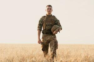 Soldier man standing against a field photo