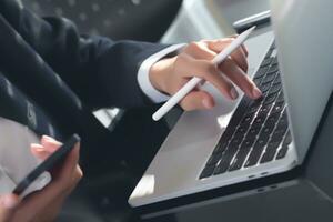 Business and Finance, Businessman using digital tablet and laptop computer at office. Business man working, touching on tablet screen and typing on laptop computer, searching business data, surfing photo