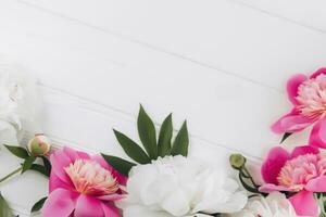 rosado y blanco peonías en un blanco de madera fondo, Copiar espacio, plano poner, saludo tarjeta. enamorado regalo. enamorado antecedentes foto