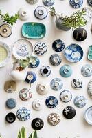 Ceramic pottery collection decorating wall. Vintage plates craft products display. photo