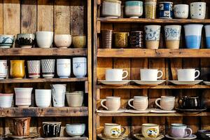 Various pottery ceramic displayed on wooden shelves at store. pottery ceramic on wooden shelves photo