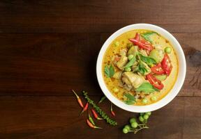 Chicken green curry Asian food, Beef green curry Thai food on a soup bowl with a mixture of herbs, vegetables and Thai red chilli spices. Top view. photo