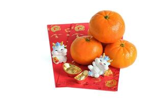 Happy New Year Chinese year of dragon 2024. Mandarin orange, dragon and gold ingots on red envelopes isolated on white background. photo