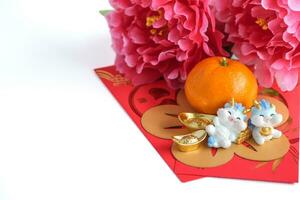 Chinese New Year of the dragon festival concept. Orange, red envelopes, two dragons and gold ingot decorated with plum blossom on white background. copy space for text. photo