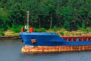 azul carga Embarcacion con largo alcanzar excavador Moviente a el Puerto foto