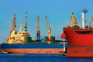 Red and blue cargo ship loading in the port of Riga photo