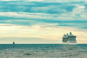White cruise liner moving to the sea at cloudy day photo