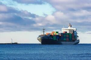 Modern grey container ship moving in still water photo