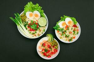 Beautiful Noodle Dish with Green Onions, Eggs, Green Pea, Red Hot Pepper, Greens and Lime on Sushi Mat. Instant Noodles with Vegetables photo