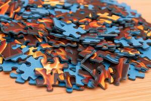 Colorful Peaces of a Mixed Jigsaw Puzzle Lie on the Wooden Table Strategy and Solving Problem Concept photo