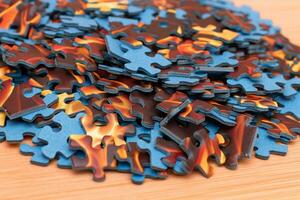 Colorful Peaces of a Mixed Jigsaw Puzzle Lie on the Wooden Table Strategy and Solving Problem Concept photo