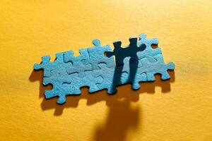 Top View of a Blue Puzzle Peaces Lie on the Yellow Background photo