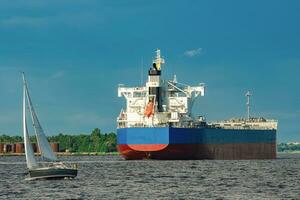 Merchandise import. Large blue cargo ship moving to Riga port photo