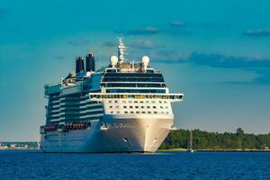 Giant white passenger ship moving past the port on a clear day photo