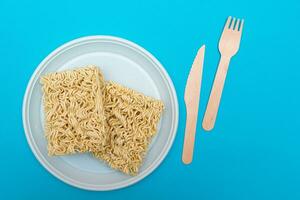 Uncooked Instant Noodles on White Plate. Raw Pasta. Dry Asian Fast Food. Quick Lunch photo