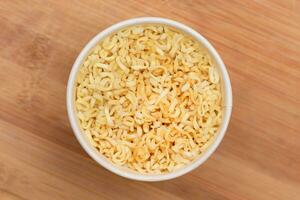 Instant Noodles in Disposable Cup on Wooden Background Top View. Asian Fast Food. Quick Lunch photo