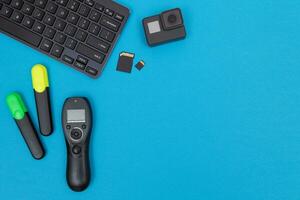 Top View of Photographer's, Videographer's or Video Blogger's Workplace. Digital Gadgets Lying on Blue Table Flat Lay photo