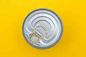 Unopened Tin Can with Blank Edge on Yellow Background. Canned Food. Aluminum Can for Safe and Long Term Storage of Food. Steel Sealed Food Storage Container photo