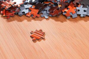 Colorful Peaces of a Mixed Jigsaw Puzzle Lie on the Wooden Table Strategy and Solving Problem Concept photo