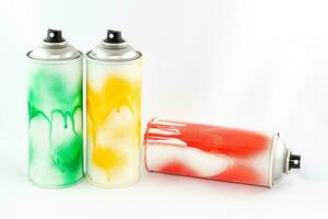 Three Colored Spray Paint Cans on White Background. Graffiti's Inventory CloseUp Shot photo