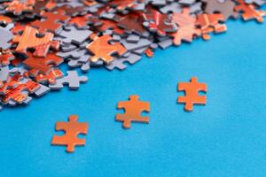 Mixed Peaces of a Colorful Jigsaw Puzzle Lie on the Blue Background Strategy and Solving Problem Concept photo