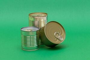 A Group of Stacked Tin Cans with Blank Edges on Green Background. Canned Food. Different Aluminum Cans for Safe and Long Term Storage of Food. Steel Sealed Food Storage Containers photo