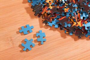 Colorful Peaces of a Mixed Jigsaw Puzzle Lie on the Wooden Table Strategy and Solving Problem Concept photo