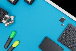 Top View of Photographer's, Videographer's or Video Blogger's Workplace. Digital Gadgets Lying on Blue Table - Flat Lay photo