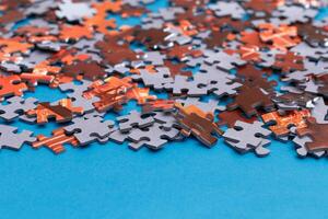 Mixed Peaces of a Colorful Jigsaw Puzzle Lie on the Blue Background Strategy and Solving Problem Concept photo