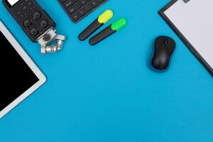 Top View of Photographer's, Videographer's or Video Blogger's Workplace. Digital Gadgets Lying on Blue Table Flat Lay photo