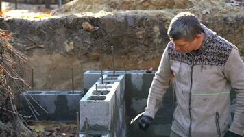 A real builder checks the horizontal level of the wall. Construction of a basement video