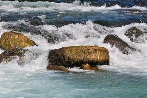 a river with rocks and water rushing over them photo