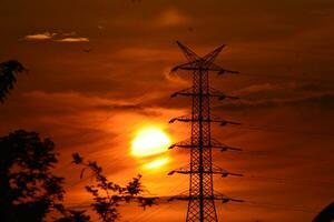 background photo of the sunrise in the morning with an electricity tower