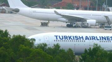 phuket, thailand - november 28, 2019. antal fot av flygbuss a330 av turkiska flygbolag passagerare plan på de bana på phuket flygplats, sida se. flygplan redo för ta av video