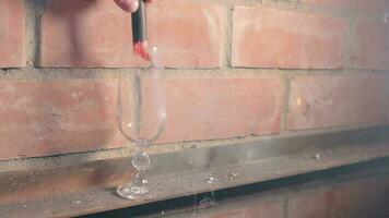 Firecracker Exploaded in a Wineglass Against a Brick Wall. The Blast Wave of a Petard Damaged the Glass and Many Small Fragments of Glass Flew in Different Directions Static Shot video