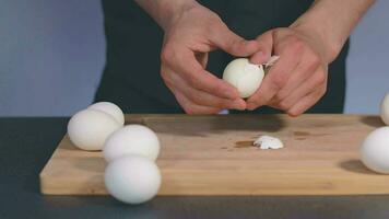koken in zwart kleding is pellen wit kip eieren en voorbereidingen treffen ingrediënten voor Koken iets dieet langzaam beweging video