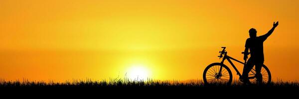 Silhouette of a happy cyclist in the meadow. Fitness and Travel Ideas photo