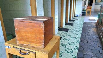 un de madera dinero caja en frente de un público baño puerta, adecuado para publicidad único y antiguo artículos foto