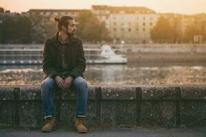 Depressed modern businessman sitting by the river.Toned image photo