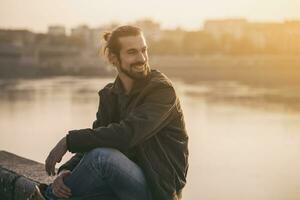 Handsome modern businessman enjoys resting by the river.Toned image photo